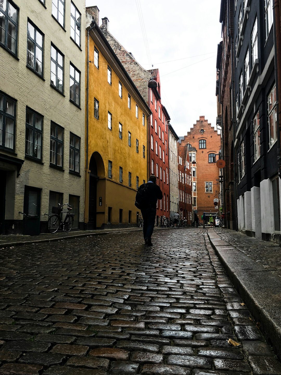 Danish documentary photographer holding a camera in an old town street