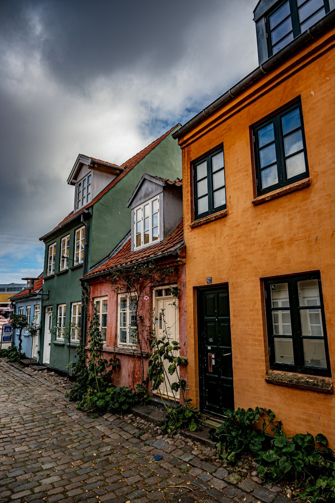 Narrow cobblestone street in a Danish town with colorful old houses